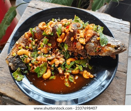 snakehead fish wade through the garden  Another hungry menu  It is a fish dish mixed with Thai herbs.  Whether it's old ginger, lemongrass, all are herbs that are beneficial to the body. Royalty-Free Stock Photo #2337698407