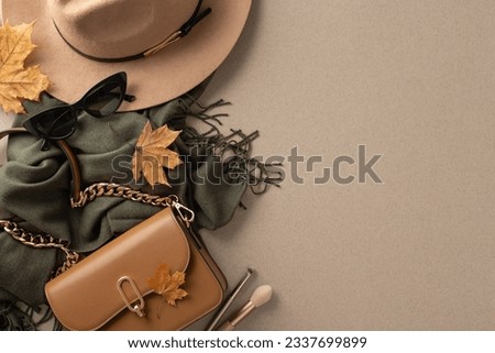 Stay stylish and cozy this fall with trendy attire: chic handbag, fashionable felt hat, black scarf and sunglasses. Top view photo on grey isolated backdrop with space for text or advertising Royalty-Free Stock Photo #2337699899