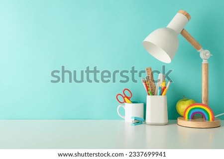 Cultivate efficient learning habits with this side-view photo featuring white desk with colorful office supplies, organizer, and lamp on a blue backdrop, accompanied by ample space for text or advert