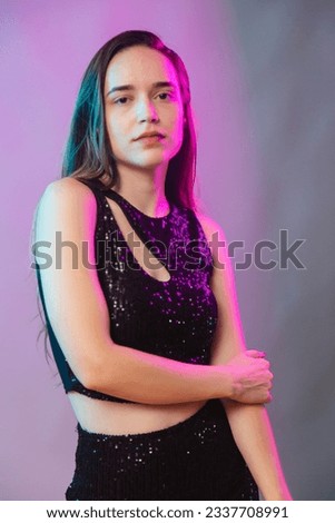 Model on blue and pink neon background, posing for photo, illuminated. vertical photo.