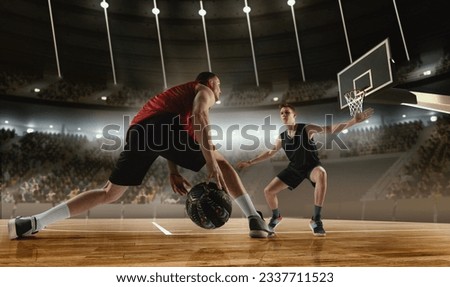 Competitive young men, basketball players in motion during match, game playing at 3D arena with flashlights. Scoring winning goal. Concept of professional sport, competition, action, hobby, game.