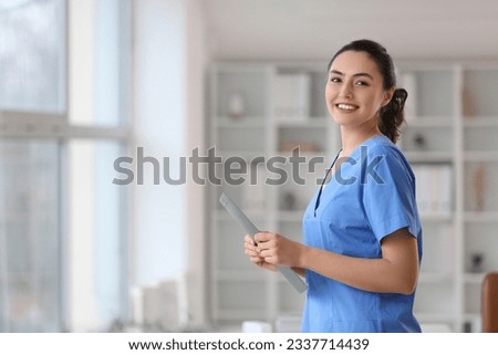Female medical assistant with clipboard in clinic Royalty-Free Stock Photo #2337714439