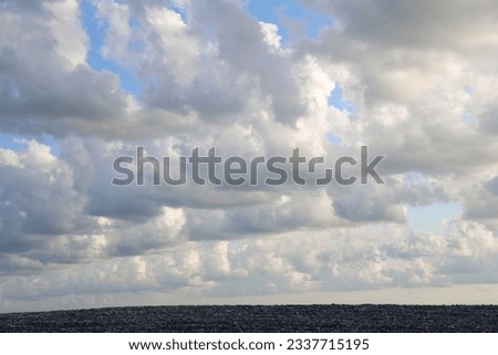 pebble road and fluffy clouds and blue sunset sky. nature background. coastal line. Black Sea.  Cloudy sky. 