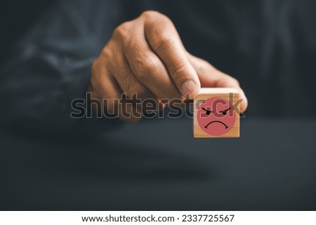 Customer dissatisfaction concept. Unhappy customer hand with a sadness emotion face on a wooden block. Bad service, low rating, and negative feedback affecting business reputation in online marketing. Royalty-Free Stock Photo #2337725567