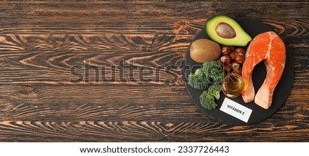 Slate plate with healthy products rich in vitamin E on wooden background with space for text Royalty-Free Stock Photo #2337726443