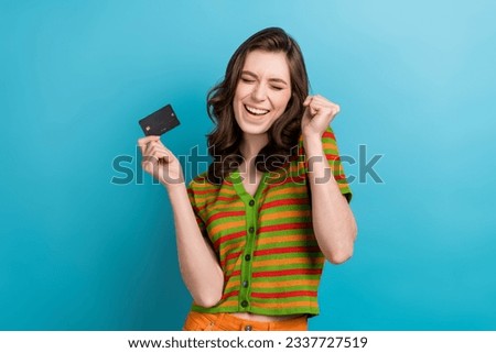 Photo of businesswoman fist up celebrate her startup receive first investors money hold debit card isolated on blue color background
