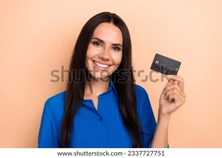 Photo of pretty cheerful person toothy smile hand hold showing plastic debit card isolated on beige color background
