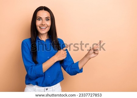 Portrait of attractive amazed lady promoter directing fingers empty space amazing sale offer news isolated beige color background