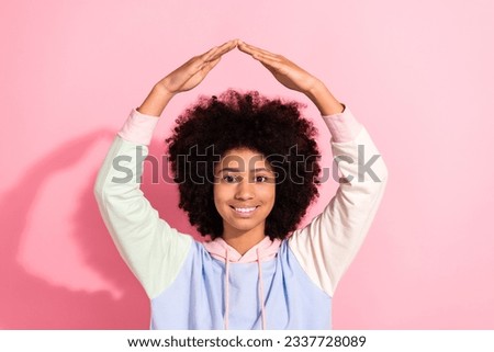 Portrait of cute positive schoolkid beaming smile arms demonstrate roof above head gesture isolated on pink color background