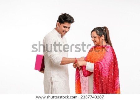 Indian good looking young brother and sister celebrating Raksha Bandhan or Rakhi festival. Royalty-Free Stock Photo #2337740287