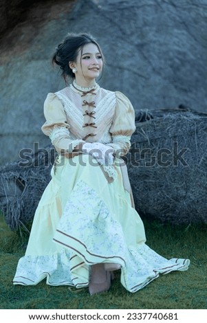 A pretty young Asian teenage girl wearing Victorian or Edwardian-era dresses is happy and relaxing on a good day. Portrait young girl in retro vintage old fashion style concept. Royalty-Free Stock Photo #2337740681
