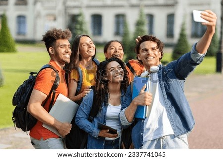 Portrait of happy multiethnic students talking selfie on smartphone outdoors, group of cheerful young multicultural college friends posing at mobile phone camera together, relaxing after classes