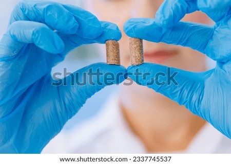 Woman worker control pellet combined feed for production food for animal in laboratory. Royalty-Free Stock Photo #2337745537