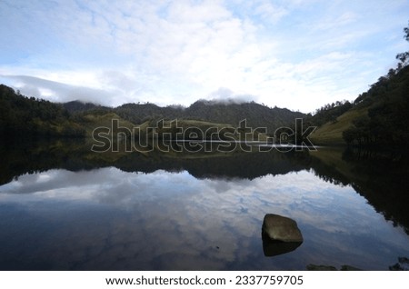 Beautiful nature background with morning light and morning reflection on the lake at Ranukumbolo lake Semeru Maountain, jawa timur, indonesia. The photo was taken by Willem Tasiam, a marathon climber