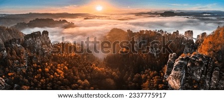 Saxon, Germany - Aerial panoramic view of the beautiful Saxon Switzerland National Park near Dresden on a foggy autumn morning with Bastei bridge, rock formation and golden autumn foliage at sunrise Royalty-Free Stock Photo #2337775917