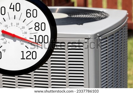Outdoor thermometer in sun with air conditioner. Hot weather, HVAC maintenance, and home energy savings concept. Royalty-Free Stock Photo #2337786103