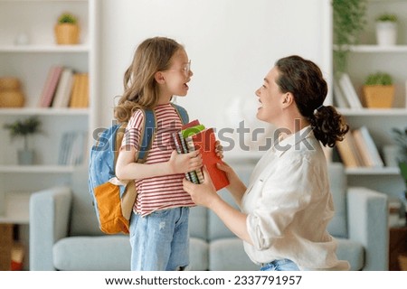 Happy family preparing for school. Little girl with mother. Royalty-Free Stock Photo #2337791957