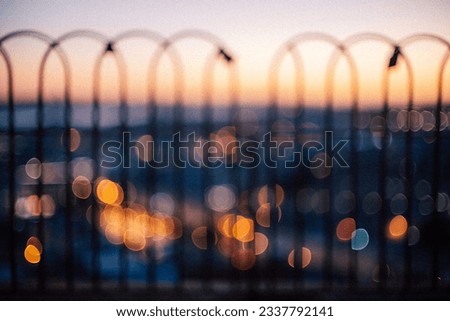 Lisbon behind a fence by the sunset with bokeh lights and out of focus