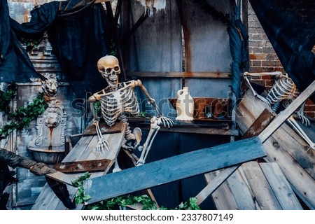 Outdoor Decor for Halloween. skeletons climbing out of the different wooden rubble. Halloween scenery. Terrible holiday photo zone on location for event. Traditions and decorations. Selective focus.