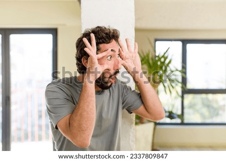 young adult crazy man with expressive pose at a modern house interior