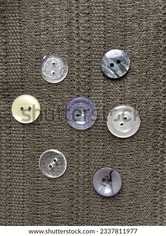 dark green background, khaki fabric with beautiful buttons, shiny olive background with natural stones, composition of buttons and natural stones