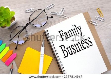 FAMILY BUSINESS - top view of an open notebook with stickers and plants in a pot. word on the page