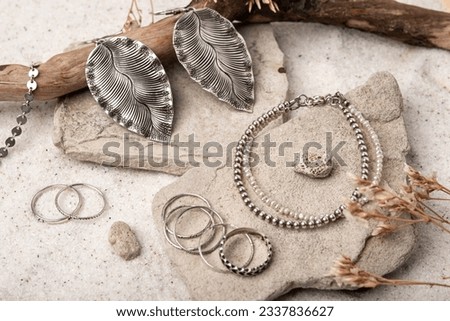 Beautiful Silver and Pearl Jewelry on white stones and sand. Various jewelry - bracelets, necklaces and rings. Royalty-Free Stock Photo #2337836627
