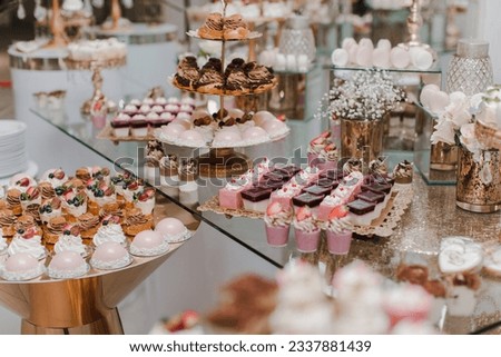 candy bar, sweets, sweets, chocolate, lollipops, cakes and macaroons are laid out on beautiful trays and decorated with flower arrangements Royalty-Free Stock Photo #2337881439