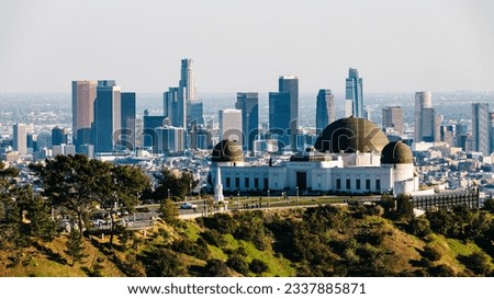 From downtown Los Angeles, the view over Griffith Observatory showcases an enchanting cityscape that dazzles with its twinkling lights against the night sky, offering a captivating blend of urban char