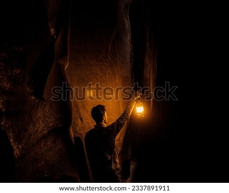 picture of a man who is holding a lamp in his hand and lookin at the mountains 