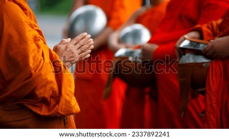 Buddhist monk holding alms bowl waitting for buddhism make merit by offering food and water at morning Royalty-Free Stock Photo #2337892241