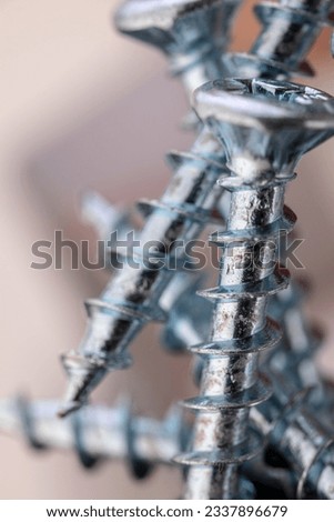Pile of shiny galvanized screws with in bokeh. Closeup of a metalware. Royalty-Free Stock Photo #2337896679
