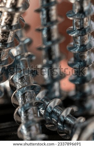 Pile of shiny galvanized screws with in bokeh. Closeup of a metalware. Royalty-Free Stock Photo #2337896691