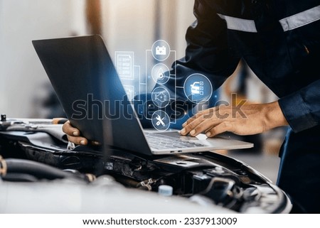 Mechanic using laptop checking up on car engines parts for fixing and repair, Smart service diagnostics software concept. Royalty-Free Stock Photo #2337913009