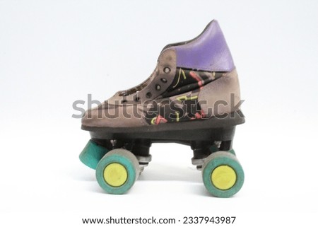 A picture of an old and used roller skate. It is bright with funky colours like purple, green and yellow and it has a graphic design on the side of the shoe. The background is fully white.