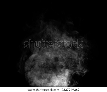 Close-up of steam or abstract white smog rising above. water droplets that can be seen that swirl beautifully from humidifier spray. Isolated on a black background