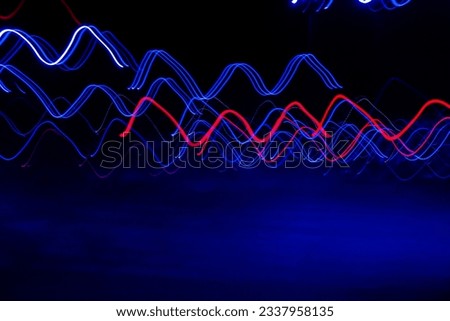 Long exposure, light painting photography, multi color swirl effect against black background. Night city lights 