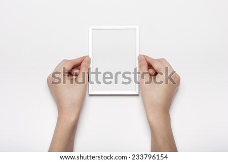 A female hands hold(grip) a steel photo(picture) frames isolated white, top view at the studio.