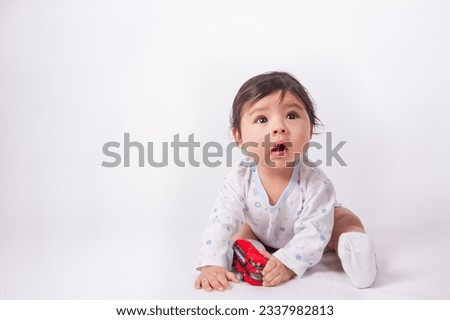 Beautiful photo of baby playing on light background in photo studio. Family and baby concept.