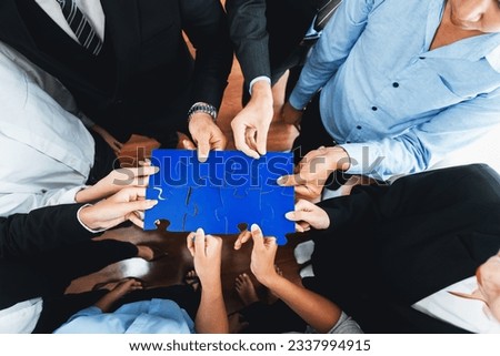 Top view multiethnic business people holding jigsaw pieces and merge them together as effective solution solving teamwork, shared vision and common goal combining diverse talent. Meticulous Royalty-Free Stock Photo #2337994915