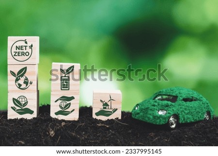 Net Zero wooden cube and green EV car model on soil for sustainable transportation for greener environment and increased natural awareness by reducing CO2 emissions and pollution concept. Alter Royalty-Free Stock Photo #2337995145