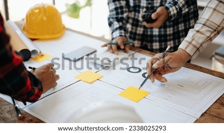 Engineer desk with object paper and tablet with blurry engineer teamwork hardworking to consults about their building project. in office