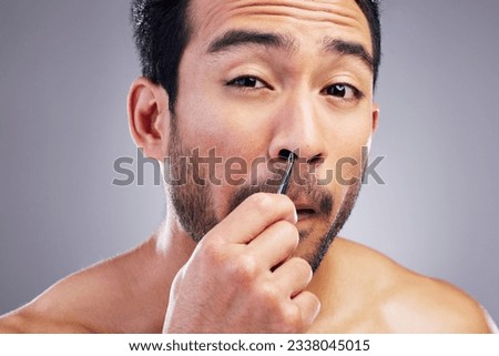 Tweezer, nose hair and portrait of man in studio for beauty, hygiene or grooming. Pain, epilation and face of an asian male person for skincare, self care and cosmetic tools on grey background