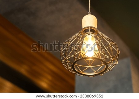 Luxury bird nest design of a metal ceiling  lighting lamp which is glowing in warmlight shade. Interior decoration object equipment, Close-up and selective focus. Royalty-Free Stock Photo #2338069351