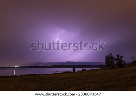 Lightning strike above the lake in night