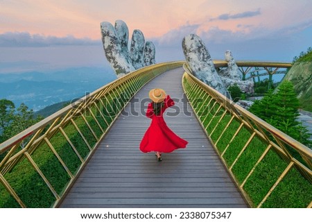 Young woman traveler in red dress enjoying at Golden Bridge in Bana hills, Danang Vietnam, Travel lifestyle concept Royalty-Free Stock Photo #2338075347