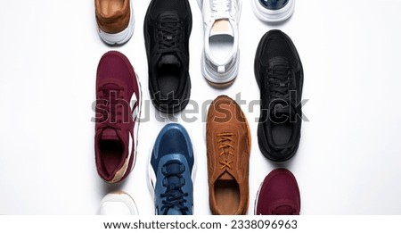 Various multi-colored pairs of men's sneakers on white background top view. Sports shoes for men or women, footwear for running, fitness, healthy lifestyle. Minimal background with sneakers Royalty-Free Stock Photo #2338096963