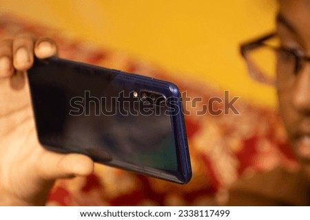Cell phone used by Indian ethnic girl child - low light edit - selective focus