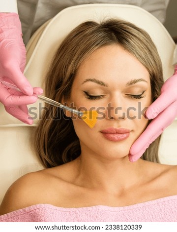 Young woman during face peeling procedure in beauty salon. Chemical face peeling Royalty-Free Stock Photo #2338120339