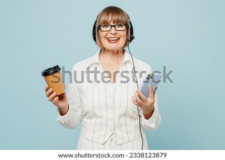 Employee operator business woman in set microphone headset for helpline assistance wears white classic clothes suit use mobile cell phone work at call center isolated on plain pastel blue background Royalty-Free Stock Photo #2338123879